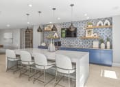 Thumbnail 21 of 38 - a kitchen with blue cabinets and a white island with chairs at Central Island Square, Daniel Island, 29492
