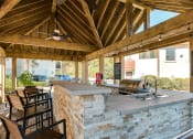 Thumbnail 25 of 54 - Outdoor grilling pavilion with bar counter seating at Two Addison Place Apartments , Pooler, GA