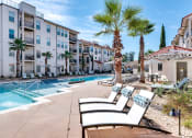 Thumbnail 20 of 54 - Swimming pool deck with palm trees  at Two Addison Place Apartments , Pooler, GA