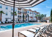 Thumbnail 23 of 54 - Swimming pool deck with chaise lounge   at Two Addison Place Apartments , Pooler, GA, 31322