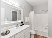 Thumbnail 8 of 33 - A white bathroom with a sink, mirror, toilet, and bathtub at Sweetgrass Landing, Mount Pleasant, SC, 29466