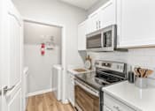 Thumbnail 2 of 33 - A kitchen with white cabinets and a black stove top at Sweetgrass Landing, Mount Pleasant, South Carolina, 29466