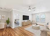 Thumbnail 3 of 33 - A living room with a television, a couch, a chair, and a potted plant at Sweetgrass Landing, Mount Pleasant, SC