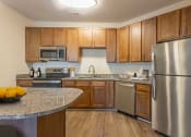 Thumbnail 5 of 54 - a kitchen with stainless steel appliances and granite counter tops at Two Addison Place, Pooler, GA, 31322