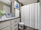 Thumbnail 5 of 20 - a bathroom with a white shower curtain and a toilet at The Village Apartments, Raleigh, NC