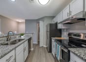 Thumbnail 6 of 20 - an open kitchen with granite counter tops and stainless steel appliances at The Village Apartments, Raleigh, 27615