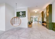 Thumbnail 15 of 16 - A hallway with a hanging chair and a sign that says Linden at The Linden Apartments, Davidson, NC