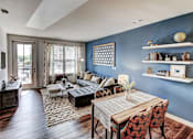 Thumbnail 4 of 16 - A living room with a blue wall and a wooden table at The Linden Apartments, Davidson, NC