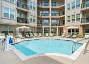 Thumbnail 8 of 16 - A large swimming pool in front of apartment buildings at The Linden Apartments, Davidson