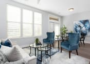 Thumbnail 4 of 33 - Living room with couch and blue chairs at St Mary's Square North Apartments, Raleigh