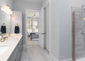 Thumbnail 19 of 33 - Primary bath with glass shower and vanity at St Mary's Square North Apartments, North Carolina