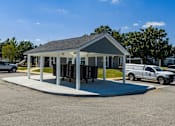 Thumbnail 12 of 46 - A small building with a parking lot in front.