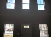 Thumbnail 33 of 47 - A room with a door, two windows and a ceiling light.