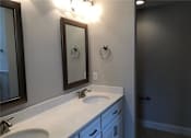 Thumbnail 30 of 47 - A bathroom with a sink, mirror, and light switch.