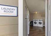 Thumbnail 16 of 46 - A laundry room with a sign on the wall.