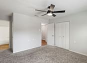 Thumbnail 42 of 46 - A room with a ceiling fan and carpeted floor.