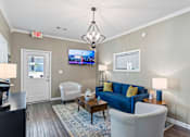 Thumbnail 20 of 46 - A living room with a blue couch and a television on the wall.