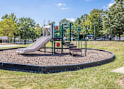 Thumbnail 8 of 46 - A playground with a green slide and a red sign.