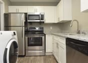 Thumbnail 25 of 39 - 1 BR Apartments in Vestavia Hills, AL - MarQ Vestavia - Kitchen with Stainless Steel Appliances, Granite Countertops, and Hardwood-Style Flooring