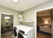 Thumbnail 27 of 39 - Two BR Apartments in Vestavia Hills, AL - MarQ Vestavia - Full-Size Front Load Washer and Dryer with Shelving and Hardwood-Style Flooring