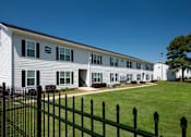 Thumbnail 1 of 46 - a white house with a green lawn and a black fence