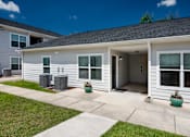 Thumbnail 7 of 46 - the front of a white house with a concrete sidewalk and grass