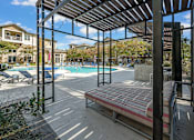 Thumbnail 13 of 91 - A pool area with a bench and a pool.