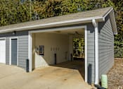 Thumbnail 9 of 62 - A garage with a grey siding and a white door is shown.