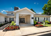 Thumbnail 21 of 43 - the front of a white building with a porch and a sign