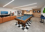 Thumbnail 40 of 57 - A pool table is in the middle of a room with a bar and a television.