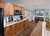 Thumbnail 14 of 46 - a kitchen with wooden cabinets and a sink and a refrigerator