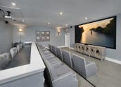 Thumbnail 34 of 50 - the theater room has a large screen tv and a long table with chairs