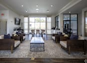 Thumbnail 21 of 62 - A spacious living room with a central coffee table and multiple seating options.