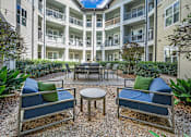 Thumbnail 6 of 91 - A patio with blue cushions and a table surrounded by plants.