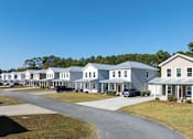 Thumbnail 1 of 47 - A row of houses with cars parked in front.