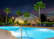 Thumbnail 10 of 36 - a swimming pool at night at a resort with palm trees
