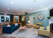 Thumbnail 14 of 36 - a living room with blue furniture and a clock on the wall