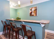 Thumbnail 17 of 36 - a bar with four chairs and a counter with a marble counter top