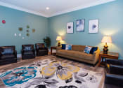 Thumbnail 22 of 36 - a living room with a couch and chairs and a rug