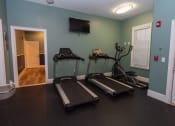 Thumbnail 19 of 36 - two treadmills and a tv in a gym room