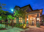 Thumbnail 2 of 91 - A house with a lit up driveway and a gate.