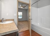 Thumbnail 68 of 91 - A bathroom with a sink, mirror, and bathtub.