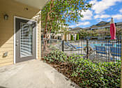 Thumbnail 78 of 91 - A view of a house entrance with a pool in the background.