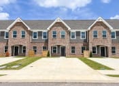 Thumbnail 1 of 13 - a large brick house with a yard and a driveway