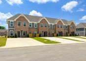 Thumbnail 2 of 13 - a large brick apartment building with a driveway