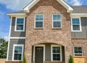 Thumbnail 3 of 13 - a large brick house with a wooden door