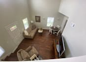Thumbnail 36 of 47 - A living room with a couch, chairs, and a television.