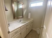 Thumbnail 45 of 47 - A bathroom with a sink, mirror, and a window.