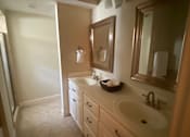 Thumbnail 46 of 47 - A bathroom with a sink, mirror, and cabinets.