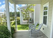 Thumbnail 17 of 47 - A porch with a rocking chair and a table.